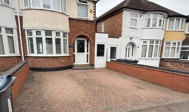 Faded, discoloured block paving driveway before painting and restoration.